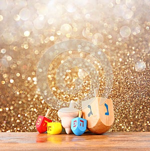 Wooden dreidels for hanukkah and glitter golden lights background