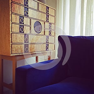 Wooden dresser and blue velvet armchair