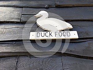 Wooden duck food sign hanging on wooden wall