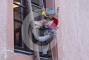 wooden dummy on a ladder by the window