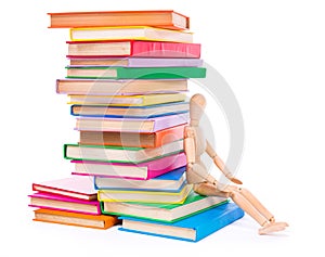 Wooden dummy puppet sitting on books