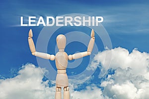 Wooden dummy puppet on sky background with word LEADERSHIP