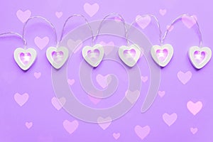 Wooden eart-shaped harland on purple background. Greeting card for st valentine`s day, Copy space