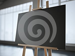 Wooden easel with a blank black canvas in modern interior.