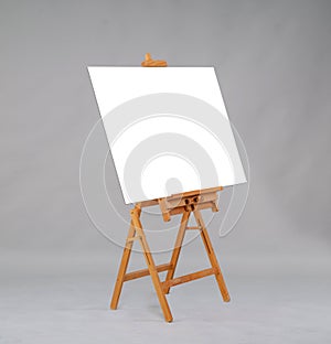 Wooden easel in the studio on a gray background