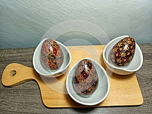 wooden egg display on a table with an Indonesian batik motif. Placed on a wooden table