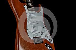 Wooden Electric Guitar Isolated Upright on a Black Background
