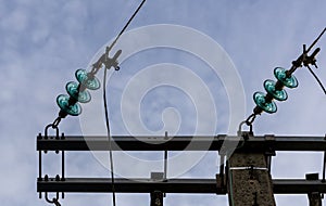 A wooden electricity pole with green insulators