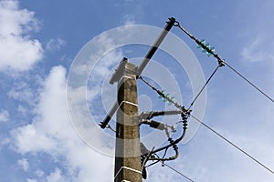 A wooden electricity pole with green insulators