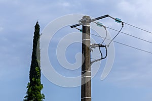 A wooden electricity pole with green insulators