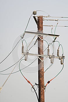 Wooden electricity pole with wires and insulators