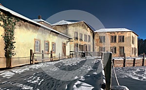 Wooden embankment with the snow of the medieval village by night