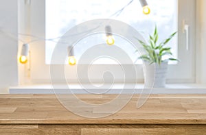 Wooden empty board in front of blurred holiday window background