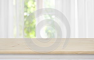 Wooden empty table in front of blurred curtained window background