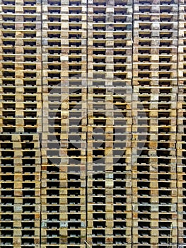 Wooden Euro pallets stacked in big industrial storehouse