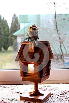 A wooden fairy-tale house lamp with a toy owl
