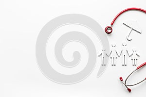 Wooden family figure with stethoscope. Life and health insurance concept