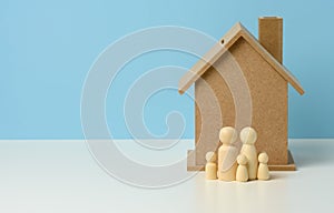 Wooden family figurines, model house. Real estate purchase, rental concept. Moving to new apartments