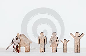 Wooden family shape and home on wooden table
