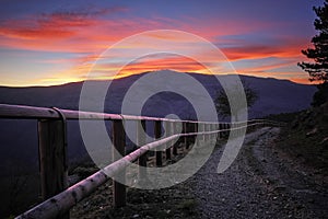 Wooden Fence Along Dirt Road At Twilight