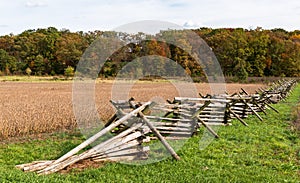 A wooden fence along a wheat field with a tree line in the distance at the Gettysburg National Military Park