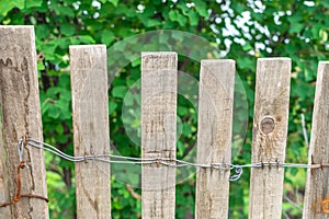 Wooden fence connected by nails and wire at garden