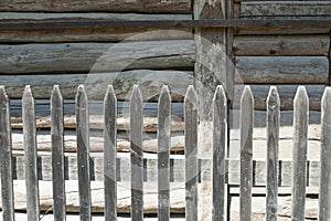 Wooden fence in front of the wooden wall of the house