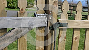 Wooden fence and gate for children on garden lawn