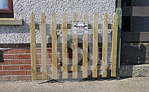 Wooden fence and gate for children on garden lawn