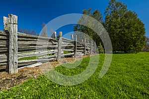 Wooden fence in green grass meadow