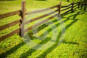 Wooden fence on green meadow