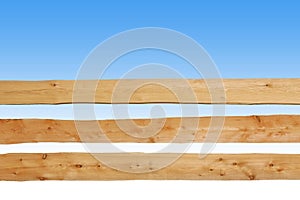 Wooden fence made of horizontal planks, against blue sky