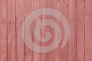 A wooden fence is painted with red paint as a background