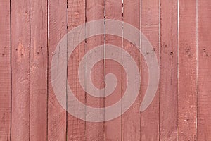 A wooden fence is painted with red paint as a background