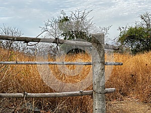 A wooden fence with a post in the middle of a field