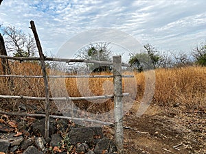 A wooden fence with a post in the middle of a field