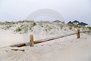 Wooden fence and sandy houses.
