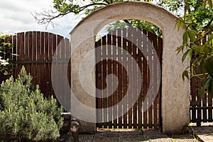 Wooden fencing garden in old style.Cottage garden with wooden wicket and trees.