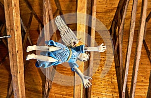 Wooden figure of an angel hovers under the roof of a church