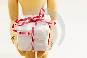 Wooden figure with gift box on white background