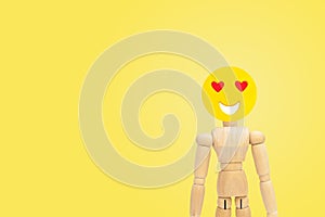 Wooden figure have feeling in love of face emotion with yellow background.