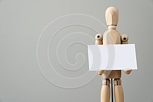 Wooden figure mannequin holding blank white paper