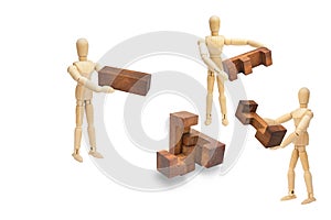 Wooden figure mannequin holding and solving wooden puzzle isolated on white background.