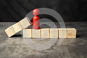 A wooden figure and a row of wooden cubes