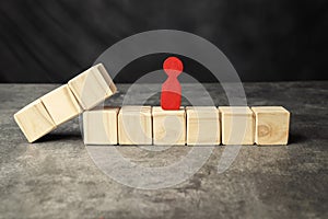 A wooden figure and a row of wooden cubes