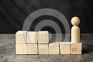 A wooden figure and a stack of wooden cubes