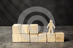 A wooden figure and a stack of wooden cubes