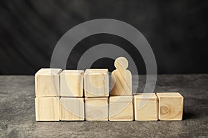 A wooden figure and a stack of wooden cubes