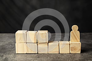 A wooden figure and a stack of wooden cubes