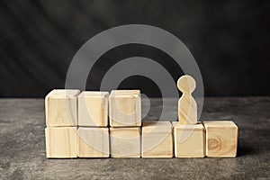 A wooden figure and a stack of wooden cubes